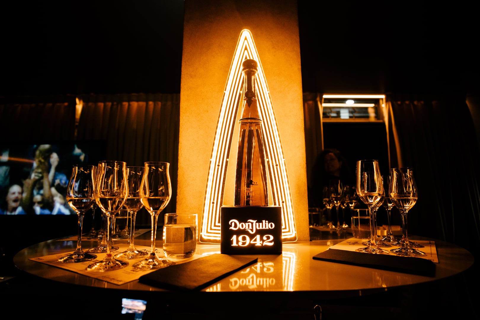 Altar dorado con la botella Don Julio 1942 y una montaña de neón