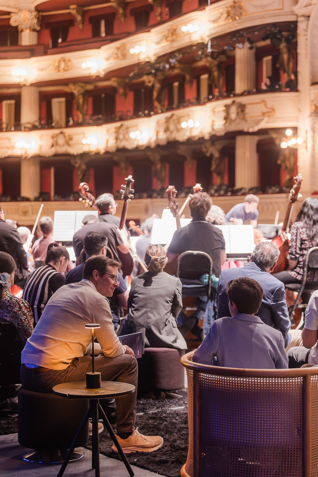 Público sentado en el escenario entre los músicos