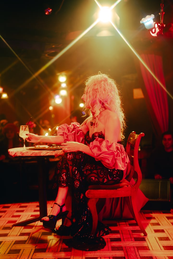 Performer sentada en una mesa del club