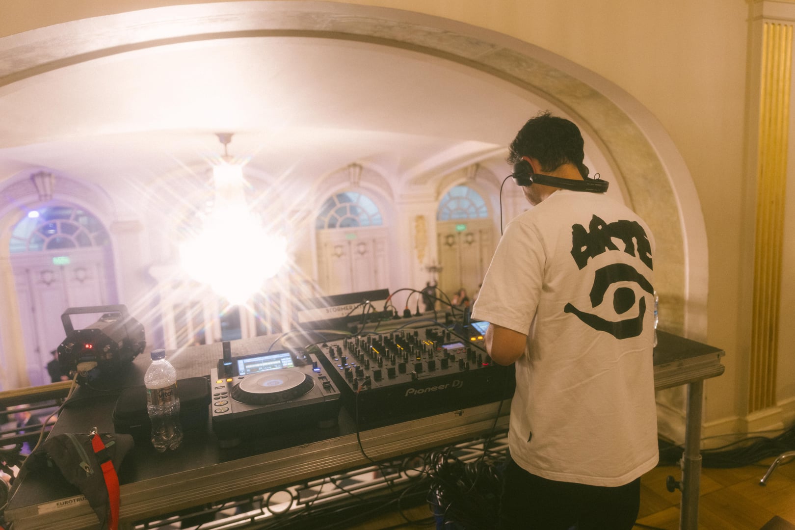 DJ tocando bajo la lámpara de araña del foyer