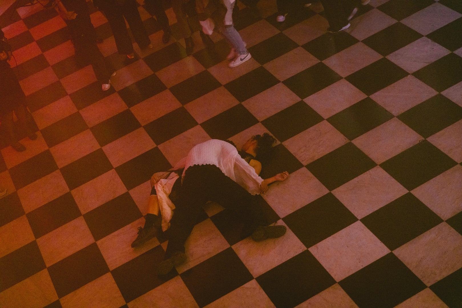 Bailarín sobre el piso ajedrezado del foyer visto desde arriba